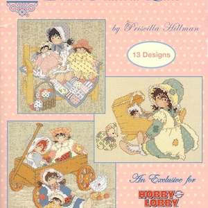 Peut inclure: Un livre de patrons de point de croix intitulé "Down Petticoat Lane" par Priscilla Hillman. La couverture présente plusieurs motifs de point de croix de poupées en bonnets et robes, avec le texte "13 Designs" et "An Exclusive for Hobby Lobby". Le fond est rose.