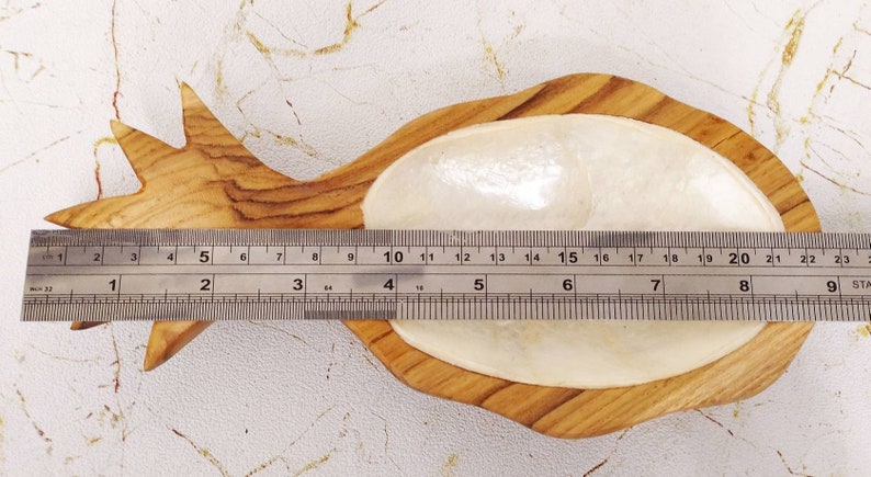 May include: A wooden pineapple-shaped dish with a white, pearlescent interior. The dish measures approximately 8 inches in length.