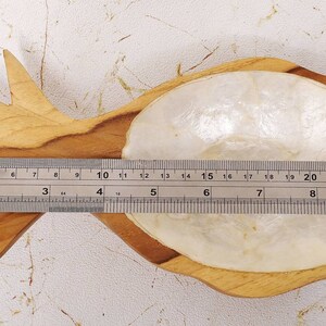May include: A wooden pineapple-shaped dish with a white mother-of-pearl inlay. The dish is approximately 9 inches long.