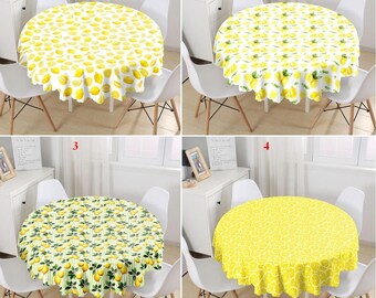 Può includere: Quattro tovaglie rotonde con stampa di limone. Le tovaglie sono bianche con limoni gialli e foglie verdi. Le tovaglie sono mostrate su tavoli rotondi con sedie bianche.