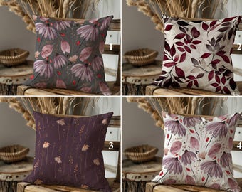 May include: Four different pillow designs with floral patterns. The pillows are all square and have a white background. The floral patterns are in shades of pink, purple, and red. The pillows are arranged in a grid pattern.