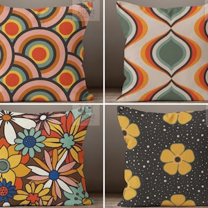 Puede incluir: Cuatro diseños diferentes de cojines decorativos con una estética retro de los años 70. Los cojines presentan patrones geométricos en tonos de naranja, amarillo, verde, marrón y blanco.