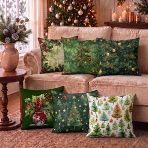 Puede incluir: Un conjunto de seis cojines cuadrados con diversos estampados navideños, que incluyen hojas de acebo y bayas, árboles de Navidad decorados, adornos dorados y un jarrón lleno de bayas rojas, dispuestos sobre un sofá tapizado en color beige.