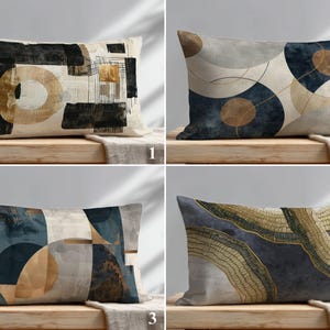 May include: Four rectangular throw pillows with abstract designs. The pillows feature geometric shapes and brushstrokes in various colors, including black, gold, beige, and navy blue. The pillows are displayed on a wooden surface.