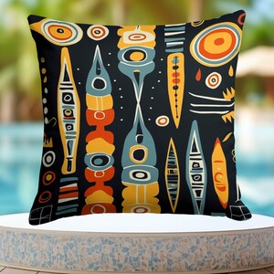 May include: A black throw pillow with a colorful geometric pattern featuring abstract shapes in shades of blue, yellow, orange, and red. The pattern is reminiscent of mid-century modern design.