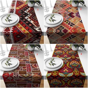 May include: Four different table runners with colorful, intricate patterns. The runners are made of fabric and feature a variety of geometric and floral designs. The runners are displayed on a table with white plates and greenery.
