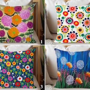 May include: Four different floral patterned pillow covers. The first pillow cover features a pink, yellow, and green floral pattern. The second pillow cover features a white background with a colorful floral pattern. The third pillow cover features a blue background with a colorful floral pattern. The fourth pillow cover features a blue background with a white and yellow floral pattern.