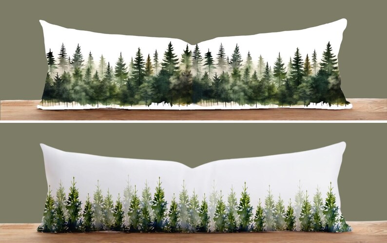 May include: Two white lumbar pillows with watercolor forest designs. The top pillow features a detailed forest scene with various shades of green trees. The bottom pillow has a simpler design with green trees.