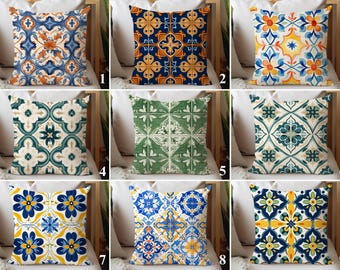 Op de afbeelding: Een verzameling decoratieve sierkussens met diverse geometrische patronen. Kussens met ontwerpen in tinten blauw, oranje, geel, groen en wit. De patronen omvatten bloemen- en tegelgeïnspireerde motieven, geschikt voor woondecoratie.