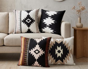 May include: A set of four square throw pillows featuring geometric patterns in black, white, and tan. The designs include diamond shapes, vertical stripes, and jagged lines. The pillows are arranged in a group, displaying a variety of contrasting color combinations and symmetrical motifs on their fabric covers.