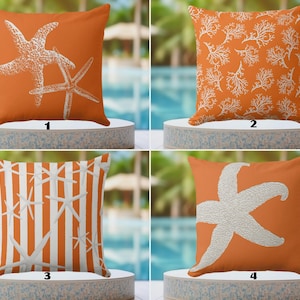 Puede incluir: Cuatro cojines decorativos naranjas con diseños blancos. Los diseños incluyen estrellas de mar, coral y patrones de rayas. Estos cojines son perfectos para añadir un tema costero a cualquier espacio habitable.