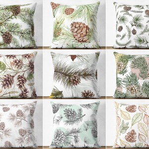 May include: Nine decorative throw pillows with various botanical designs. The pillows feature illustrations of pine cones, pine needles, and leaves in shades of green, brown, and white. The designs vary in style, from detailed watercolor to sketched outlines.