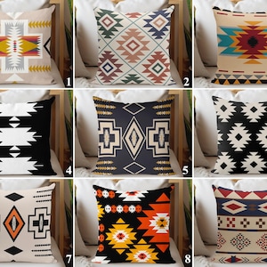 May include: Collection of decorative throw pillows with geometric patterns in various colors. Pillows feature designs in black, white, orange, yellow, red, blue, and beige. The patterns include diamonds, triangles, and other shapes.