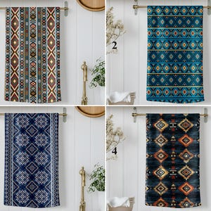 May include: Four decorative hand towels with different patterns are displayed. The towels are hanging on a gold towel rack. The patterns include geometric designs in various colors, such as red, blue, and brown. The towels are made of a soft material.