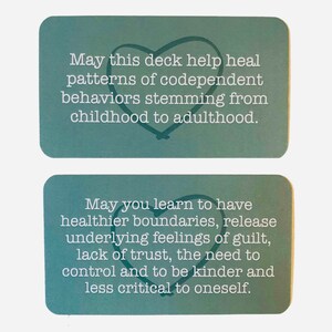 May include: Two teal blue affirmation cards with white text and a heart symbol. The first card reads "May this deck help heal patterns of codependent behaviors stemming from childhood to adulthood." The second card reads "May you learn to have healthier boundaries, release underlying feelings of guilt, lack of trust, the need to control and to be kinder and less critical to oneself."