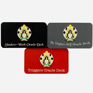 May include: Three oracle decks with black, gray, and red backgrounds. Each deck features a woman meditating with a moon and stars design. The text on the decks reads "Shadow-Work Oracle Deck", "My Higher-Self Oracle Deck", and "Triggers Oracle Deck".