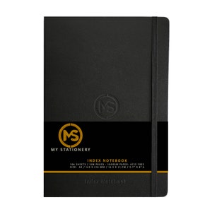 May include: Black index notebook with a gold and black band across the middle. The notebook has a black elastic band closure. The text "MY STATIONERY" and "INDEX NOTEBOOK" are printed on the cover. The notebook is 5.7" x 8.3".