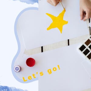 May include: A child's hand paints a yellow star on a white sheet of paper. A set of watercolour paints and coloured pencils are on the table. The paper also has the words "Let's go!" written in yellow.