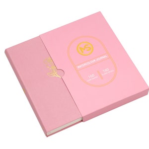 May include: A pink watercolour journal with a gold embossed logo and the text "WATERCOLOUR JOURNAL", "160 GSM PAPER", and "160 PLAIN PAGES".