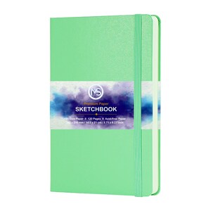 Puede incluir: Un cuaderno de bocetos verde menta con cierre de banda el&aacute;stica a juego. La portada presenta una banda blanca con el texto "Premium Paper SKETCHBOOK". El cuaderno contiene 120 p&aacute;ginas sin &aacute;cido y mide 14,5 x 21 cm.