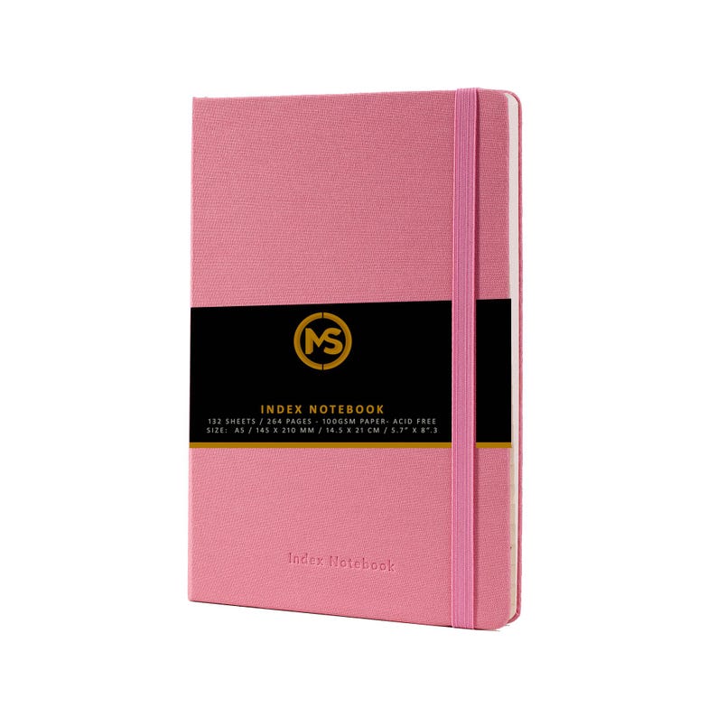 Pode incluir: Um caderno de &iacute;ndice rosa com fecho el&aacute;stico preto e um r&oacute;tulo preto com letras douradas que diz "MS INDEX NOTEBOOK 132 SHEETS / 264 PAGES - 100GSM PAPER - ACID FREE SIZE: A5 / 145 X 210 MM / 14.5 X 21 CM / 5.7" X 8.3"