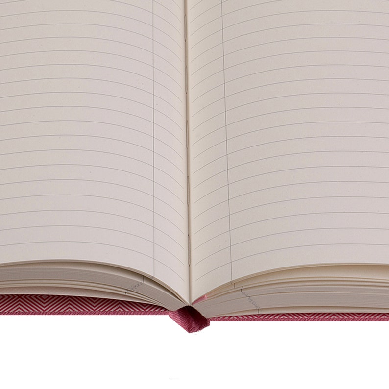 Pode incluir: Um caderno aberto com p&aacute;ginas pautadas e uma capa com padr&atilde;o chevron rosa.