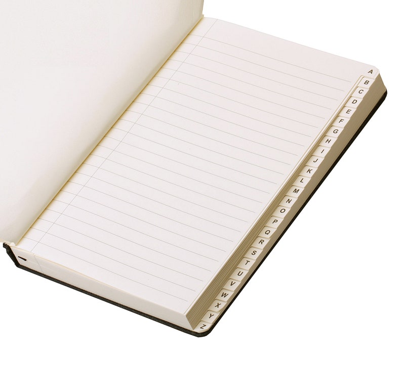 Pode incluir: Um caderno aberto, com linhas, com capa preta e um &iacute;ndice alfab&eacute;tico na borda das p&aacute;ginas.