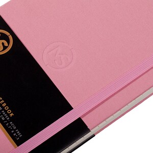 Pode incluir: Um caderno de &iacute;ndice rosa com fecho de banda el&aacute;stica preta. A capa tem um logotipo em relevo e o texto "MS MY STATIONERY INDEX NOTEBOOK 132 SHEETS / 264 PAGES - 100GSM PAPER - ACID FREE SIZE: A5 / 14.5 X 210 MM / 14.5 X 21 CM / 5.7" X 8.3"  Index Notebook".
