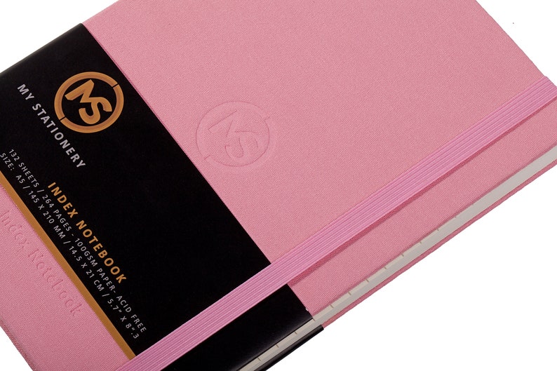 Pode incluir: Um caderno de &iacute;ndice rosa com fecho de banda el&aacute;stica preta. A capa tem um logotipo em relevo e o texto "MS MY STATIONERY INDEX NOTEBOOK 132 SHEETS / 264 PAGES - 100GSM PAPER - ACID FREE SIZE: A5 / 14.5 X 210 MM / 14.5 X 21 CM / 5.7" X 8.3"  Index Notebook".
