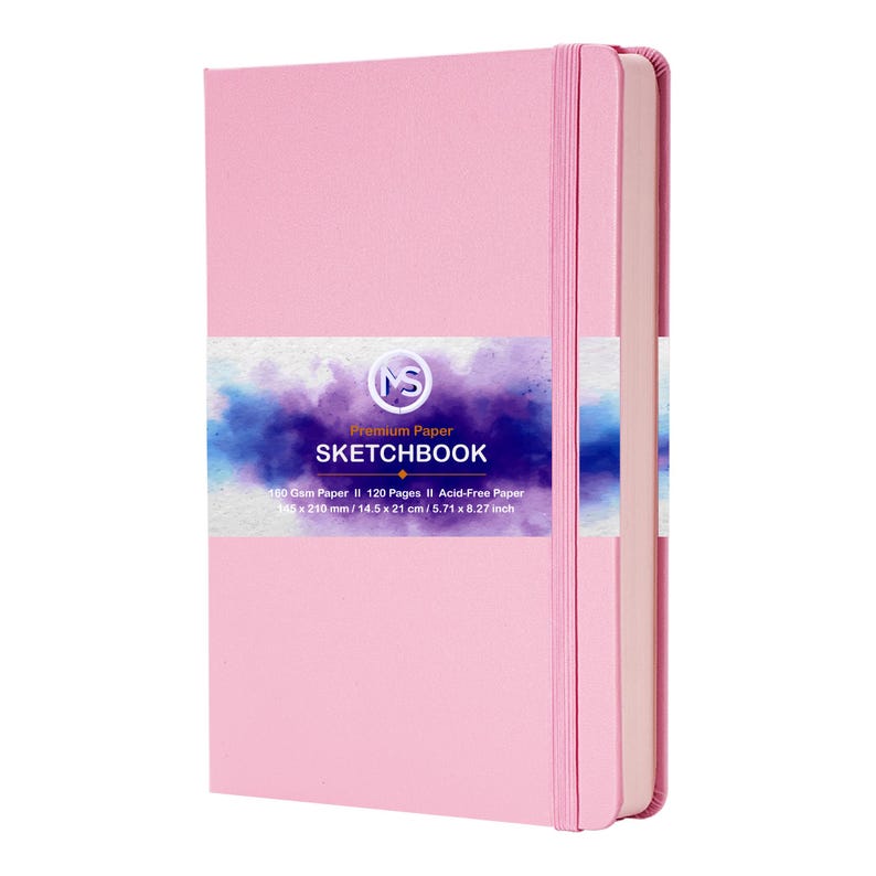 Puede incluir: Un cuaderno de bocetos rosa con cierre el&aacute;stico a juego. La portada presenta una etiqueta con el texto "Premium Paper Sketchbook". El cuaderno contiene 120 p&aacute;ginas sin &aacute;cido y mide 14,5 x 21 cm.