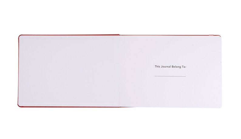 May include: A red journal with a blank page open to the inside cover. The inside cover has the text "This Journal Belong To:" printed on it.