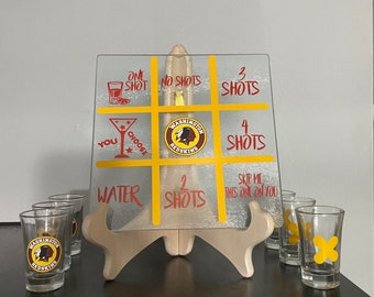 Glass tic tac toe game board with shot glass x's and o's