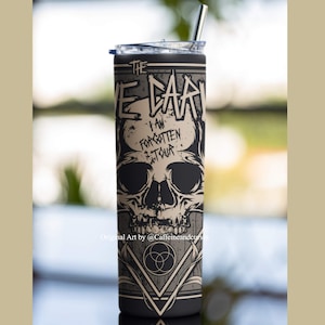 以下が含まれることがあります： 黒と白のステンレス製のタンブラーで、骸骨のグラフィックと「The  I Am Forgotten Tour」の文字が書かれています。タンブラーには黒い蓋とストローが付いています。