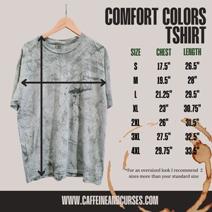 Puede incluir: Una camiseta gris de te&ntilde;ido anudado con una tabla de tallas que muestra las medidas de pecho y longitud en pulgadas. La tabla incluye las tallas S, M, L, XL, 2XL, 3XL y 4XL. El texto "COMFORT COLORS TSHIRT" est&aacute; en la parte superior de la tabla. El texto "WWW.CAFFEINEANDCURSES.COM" est&aacute; en la parte inferior de la tabla.