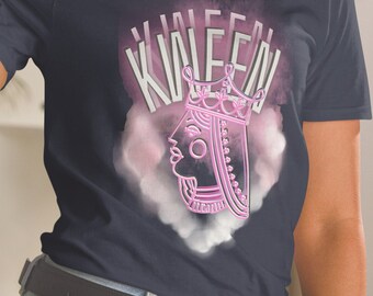May include: A navy blue t-shirt with a pink and white graphic of a queen of hearts playing card with the text "QUEEN" above it.