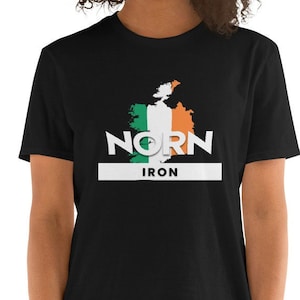 Pode incluir: Camiseta preta com um contorno branco da Irlanda com as cores da bandeira irlandesa. O texto "Norn Iron" é impresso em branco abaixo do contorno.