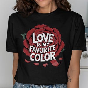 Könnte beinhalten: Schwarzes T-Shirt mit einem roten Rosenmotiv und dem Text "Love is my favorite color".