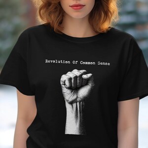 May include: Black t-shirt with a white fist and the text "Revolution of Common Sense" printed on the front.