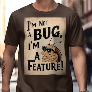 Könnte beinhalten: Braunes T-Shirt mit einem Cartoon-Kakerlaken, die eine Sonnenbrille trägt, und dem Text "I'm Not a Bug, I'm a Feature!". Das Design ist auf einem hellbraunen Hintergrund gedruckt.
