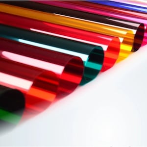 Puede incluir: Una colección de tubos de plástico translúcidos de varios colores dispuestos en fila. Los tubos son de varios tonos de rojo, naranja, amarillo, verde, azul y morado.