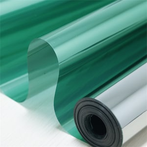 Puede incluir: Un rollo de película para ventanas verde con un revestimiento reflectante plateado. La película está enrollada y lista para ser instalada.
