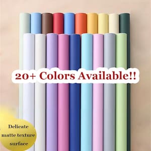 Può includere: Una collezione di carta arrotolata in vari colori, tra cui bianco, blu, rosa e verde. L'immagine presenta il testo "20+ Colors Available!!" e "Delicate matte texture surface."