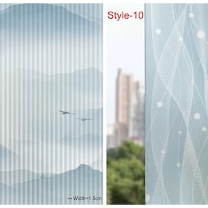 May include: Two window film samples with different designs. The left sample features a light blue and white mountain scene with a striped pattern. The right sample features a light blue and white abstract design with a wavy pattern. Both samples are 1.5 cm wide.