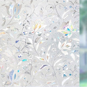 Könnte beinhalten: Dekorative Fensterfolie mit floralem Muster. Das Design zeigt weiße und irisierende Blumen, Blätter und Ranken vor einem mattierten Hintergrund. Die Folie erzeugt einen Glasmalerei-Effekt und verleiht Fenstern Privatsphäre und Stil.