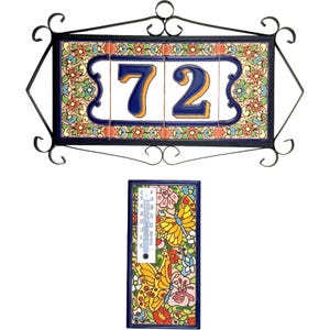 May include: A decorative address sign with the number 72 in blue, set on a floral tile background, framed in black wrought iron. Below, a matching thermometer with butterfly and floral designs.