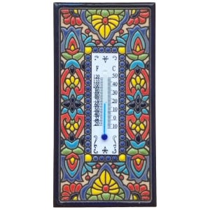 May include: A rectangular ceramic thermometer with a vibrant floral pattern. The thermometer shows both Fahrenheit and Celsius scales. The background features blue, yellow, red, and cream hues. The thermometer reads approximately 21 degrees Celsius.