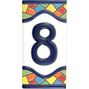 Puede incluir: Azulejo cerámico rectangular con el número 8 en azul oscuro. El azulejo tiene un fondo blanco con un borde decorativo de formas geométricas coloridas en azul, amarillo, naranja y verde.