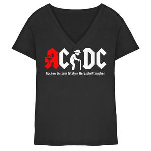 Könnte beinhalten: Schwarzes V-Ausschnitt-T-Shirt mit weißem und rotem Aufdruck. Der Aufdruck zeigt den Text "AC/DC" in einer stilisierten Schriftart und eine ältere Person mit einem Gehstock. Darunter steht der Text "Rocken bis zum letzten Herzschrittmacher."