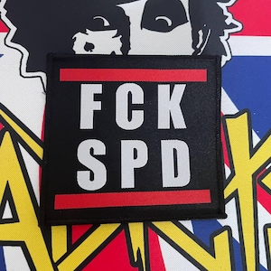 May include: Black patch with red borders and white text that reads "FCK SPD".