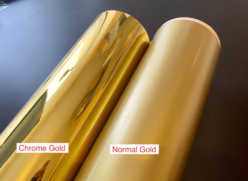 May include: Two rolls of gold vinyl, one chrome and one normal. The chrome gold vinyl has a highly reflective, shiny surface. The normal gold vinyl has a matte finish. The text "Chrome Gold" and "Normal Gold" are visible.
